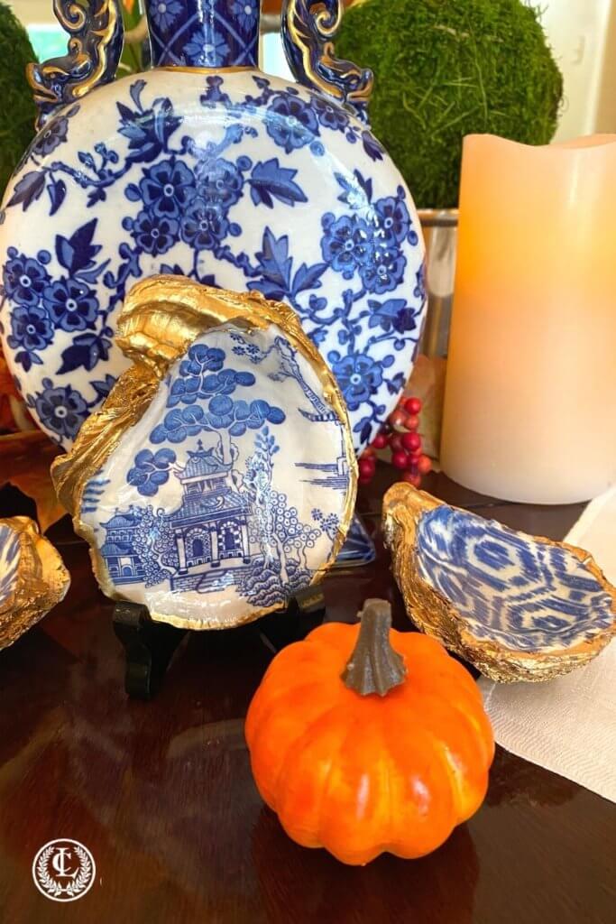 Blue and white oyster shell dishes create a festive fall mood for the Thanksgiving table centerpiece.